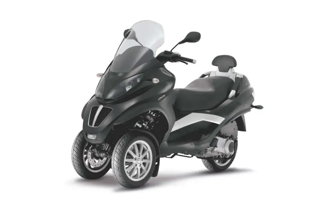 Elegante moto con dos ruedas delanteras, parabrisas alto y asiento doble.