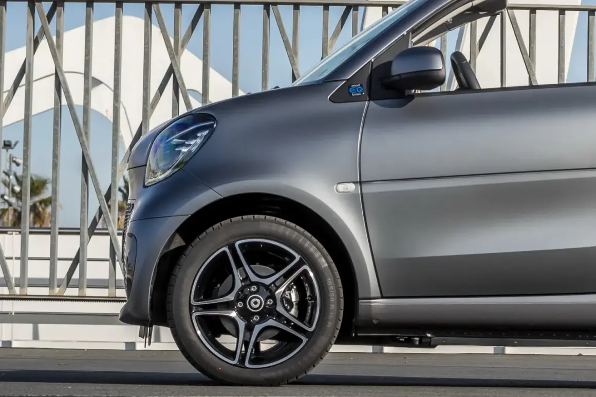 Smart EQ fortwo con vernice opaca auto grigio scuro, dettaglio del parafango anteriore e cerchio in lega.