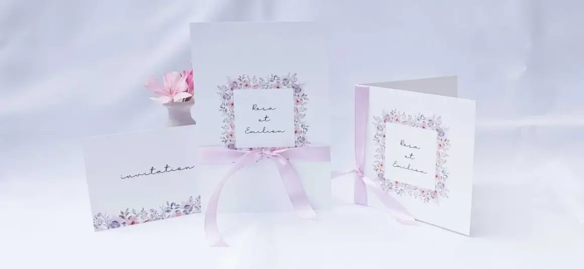 Trois faire-part de mariage délicats, ornés de fleurs pastel et de rubans roses. L'un d'eux mentionne "Rosa et Emilien".