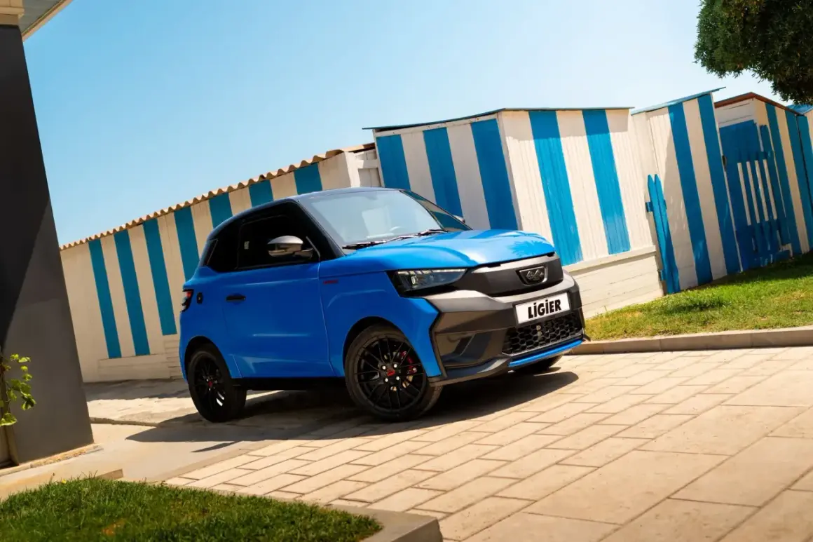 Voiturette bleue Ligier garée devant des cabines de plage rayées. Idéale pour la nouvelle loi voiture sans permis.