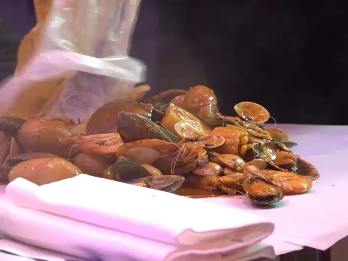 Un festin de fruits de mer à Paris : crevettes, moules et palourdes baignant dans une sauce savoureuse.