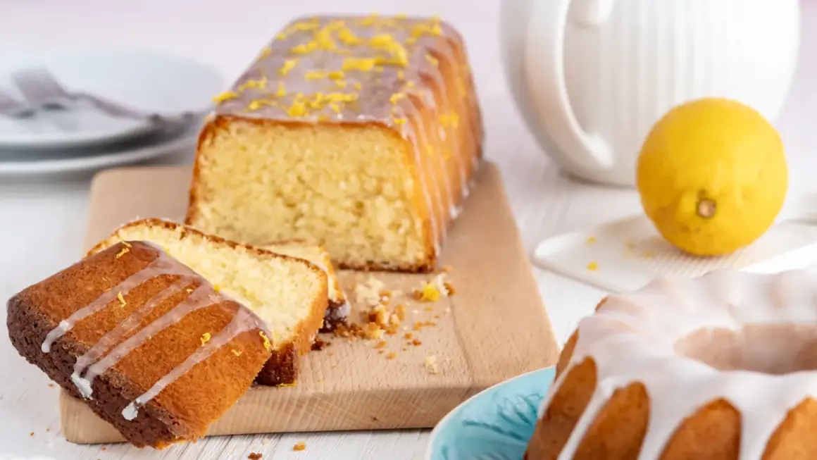 Zitronenkuchen wie bei Oma: saftiger Rührkuchen mit Zuckerguss und frischer Zitrone, daneben ein Gugelhupf.