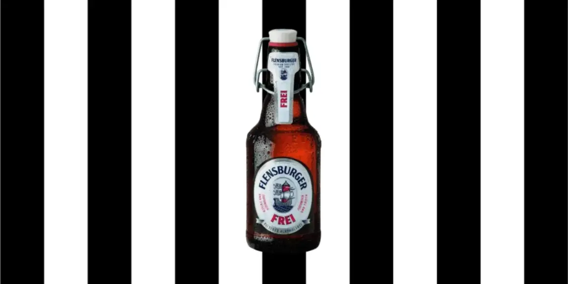 Flasche Flensburger Pilsener Alkoholfrei, mit Bügelverschluss, vor schwarz-weißen Streifen.