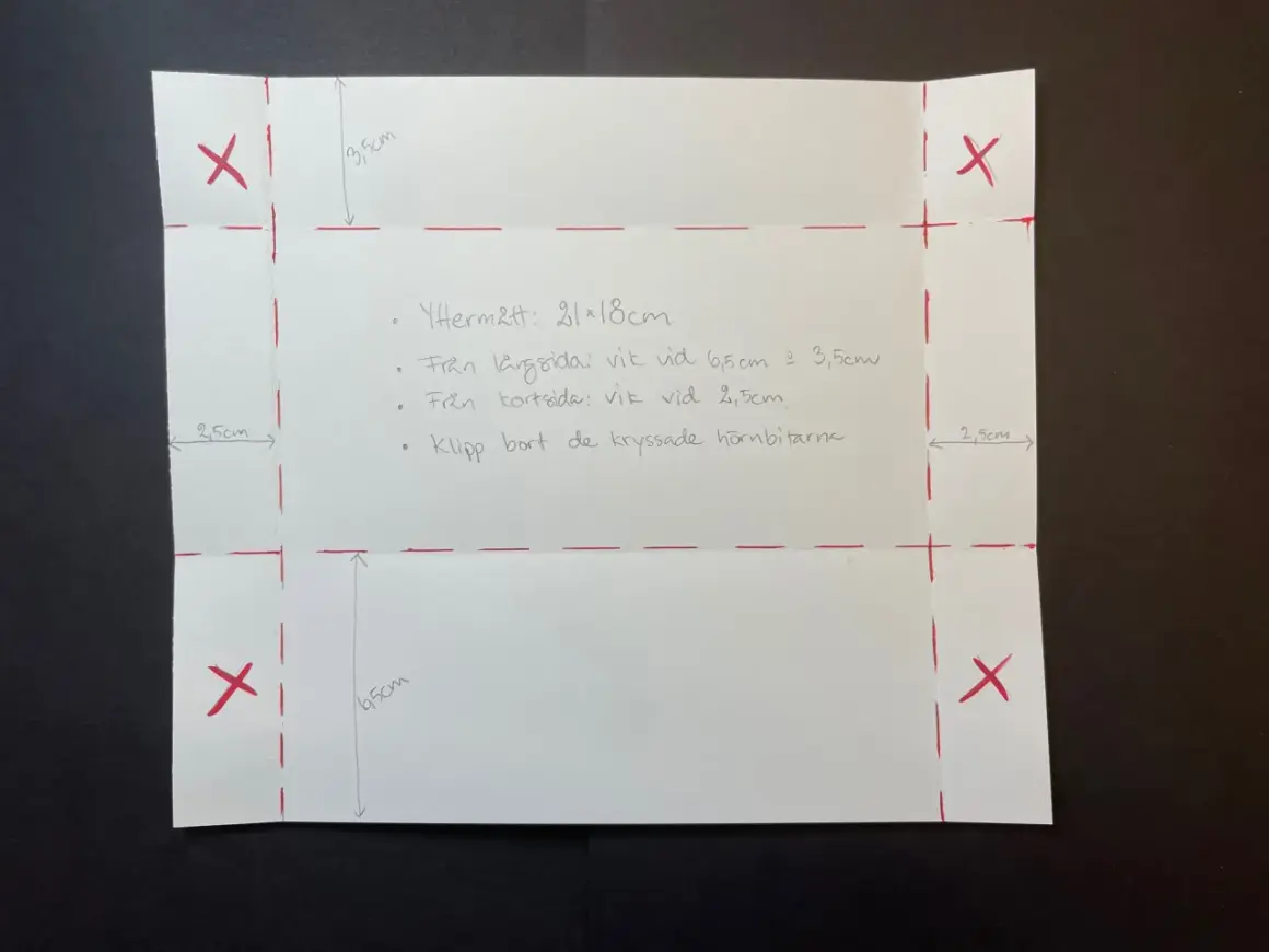 Instruktioner för hur viker man ett kuvert. Papper med mått och röda linjer visar hur man klipper och viker.