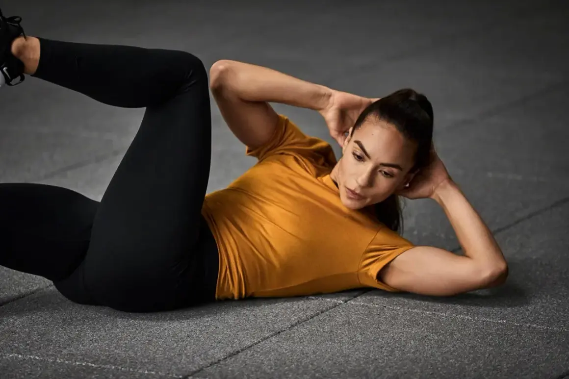 Frau macht Crunches, eine Übung für die Bauchmuskeln, auf dem Boden liegend.