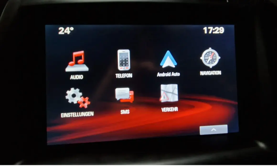 Ekran multimediów w Oplu Astrze K. Widoczne ikony: Audio, Telefon, Android Auto, Nawigacja, Ustawienia, SMS, Ruch. Temperatura 24°, godzina 17:29.