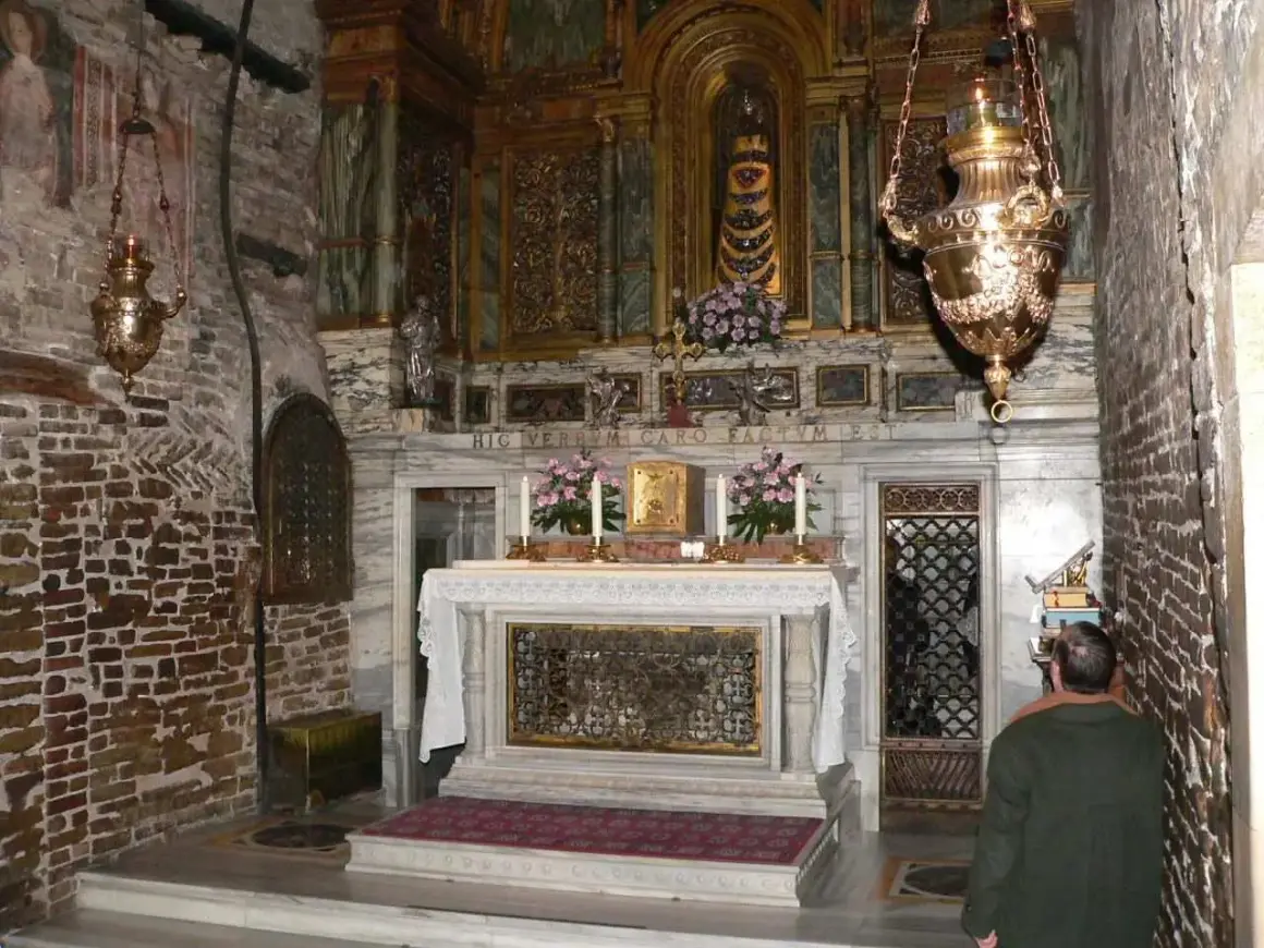 Wnętrze kaplicy z ołtarzem i obrazami. Widać tu elementy litanii loretańskiej do Najświętszej Maryi Panny.
