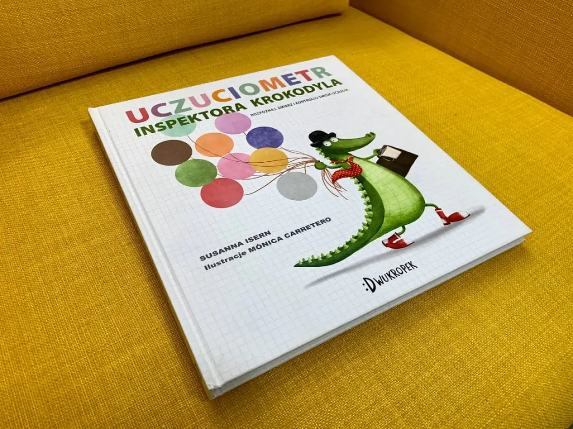 Okładka książki "Uczuciometr Inspektora Krokodyla" z zabawnym, zielonym krokodylem w kapeluszu i z walizką.