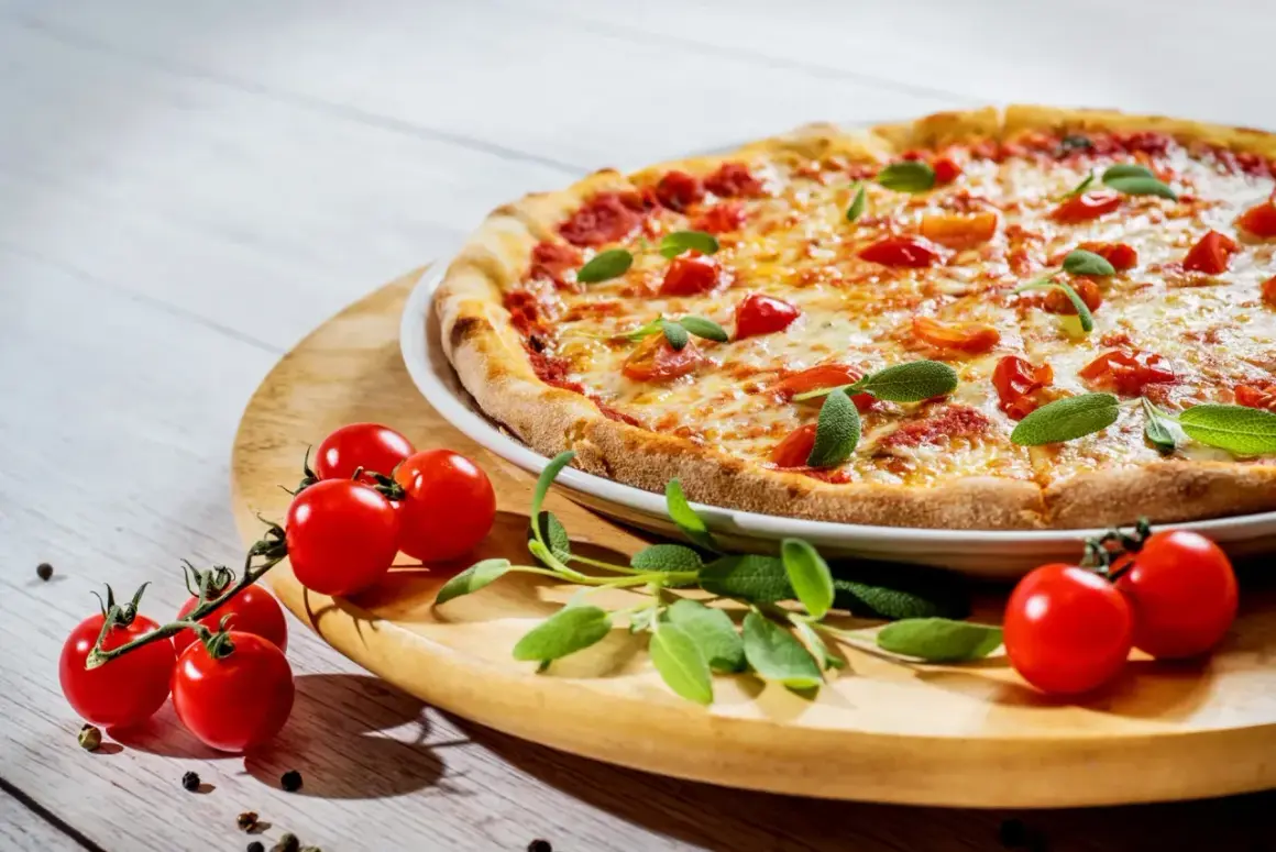 Pyszna pizza z pomidorkami i bazylią, choć ser może podnosić cholesterol, smakuje wybornie.