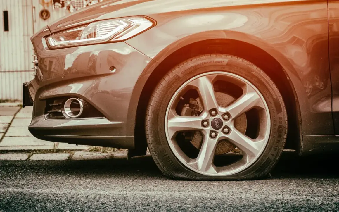 Pneu à plat sur une Ford. L'inconvénient d'une bombe anti-crevaison est qu'elle ne peut pas réparer une crevaison aussi grave.