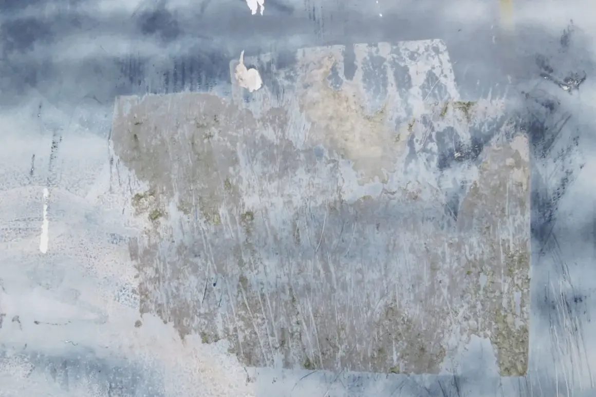 Texture de papier peint foncé avec des traces de colle à enlever, révélant des zones plus claires et des éraflures.