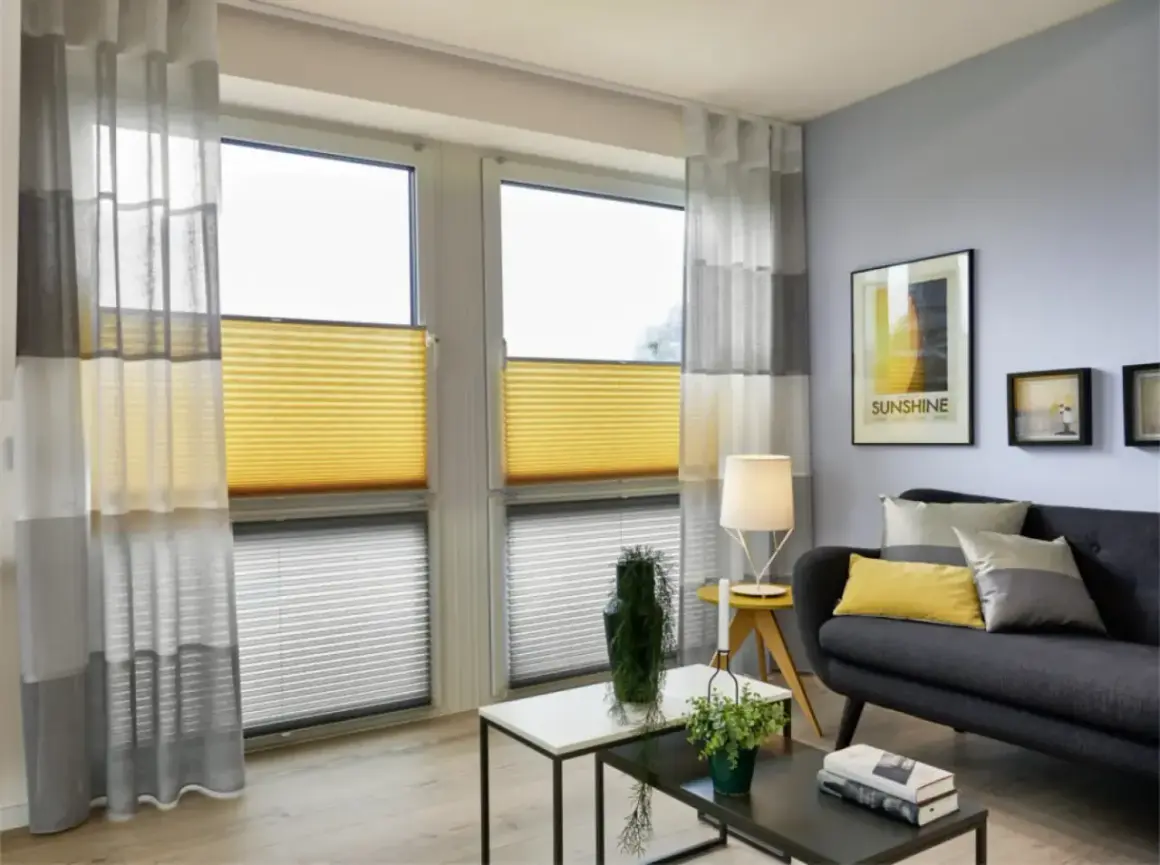 Modernes Wohnzimmer mit stilvoller Kombination aus gelben Wabenplissees und transparenten Gardinen.