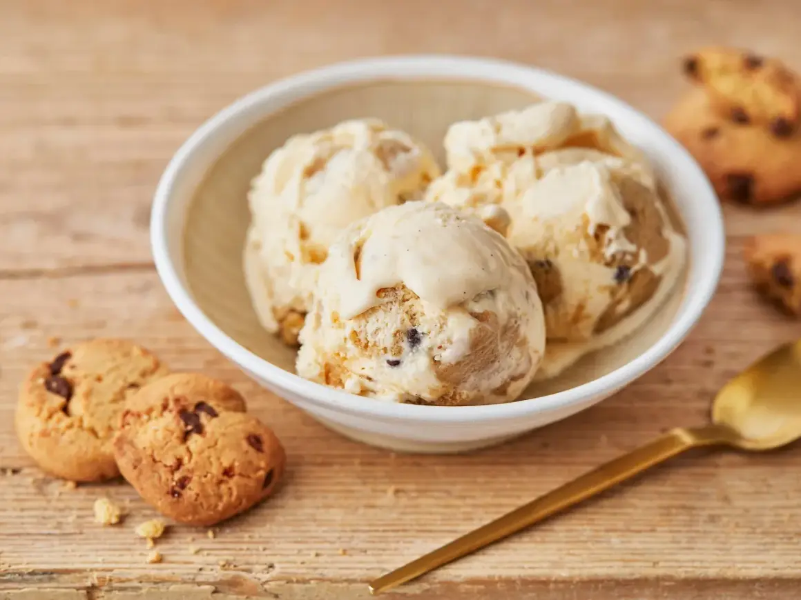 Schüssel mit cremigem Cookie Dough Eis, daneben Kekse und Löffel. Perfekt, um Cookie Dough Eis selber machen zu lernen.