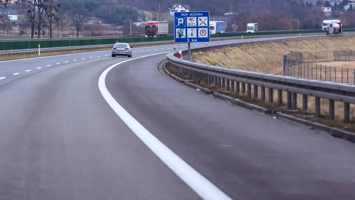 Autostrada z pasem awaryjnym. Znak informuje o MOP MSZANA, toalecie, busach i odległości 5 km.