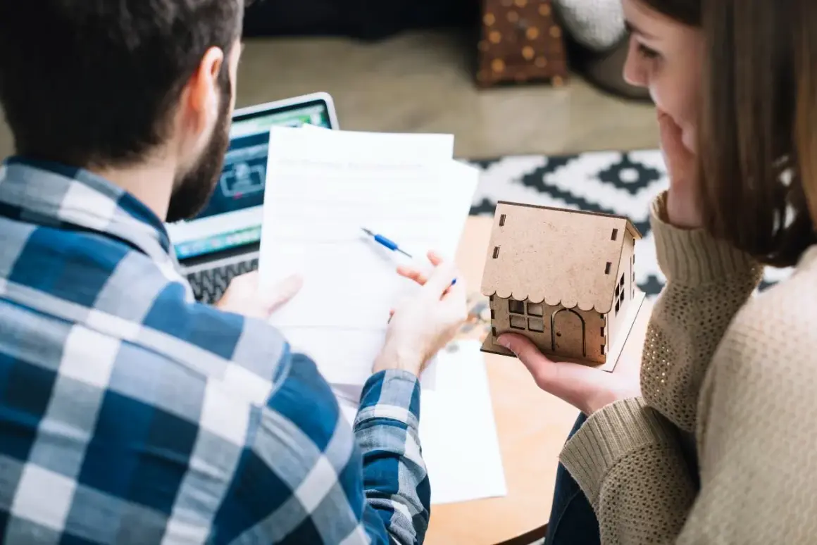 Pareja revisa documentos, planeando el futuro de su hogar, cuando un contrato de alquiler se convierte en indefinido.