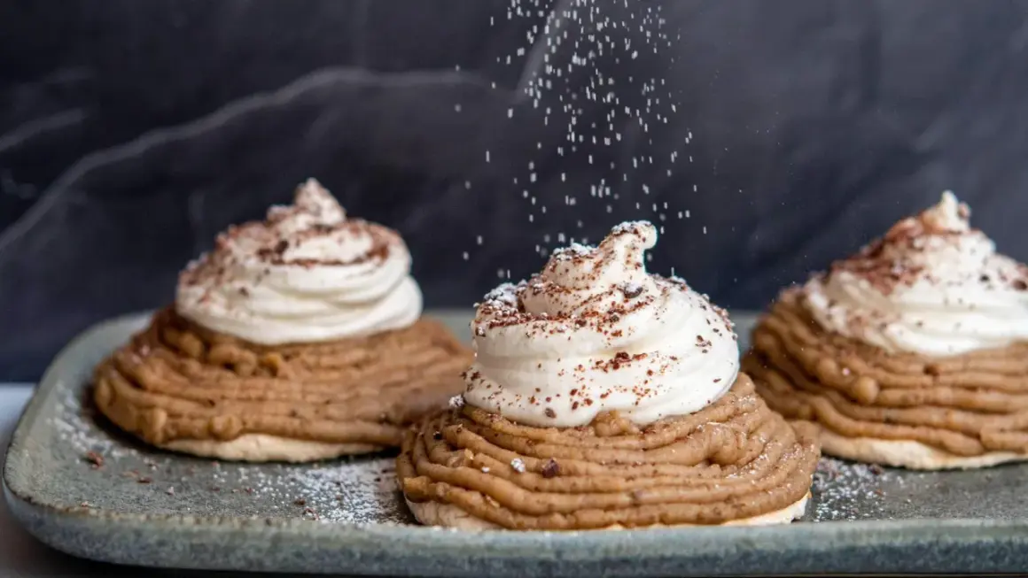 Deliciosas tartas Mont Blanc con crema batida y espolvoreadas con azúcar glas y cacao.