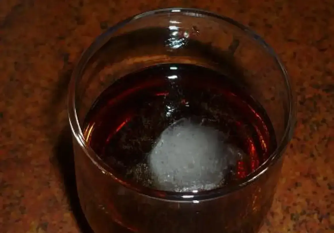 Szklanka z bursztynowym trunkiem i kostką lodu. Czekam na ten wyjątkowy metaxa smak.