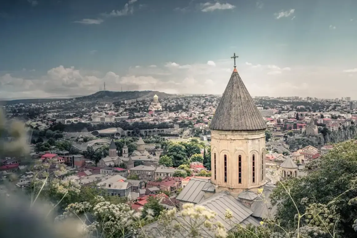 Widok na Tbilisi z kościołem w pierwszym planie. Marzysz o podróży? Sprawdź, ile trwa lot do Gruzji!