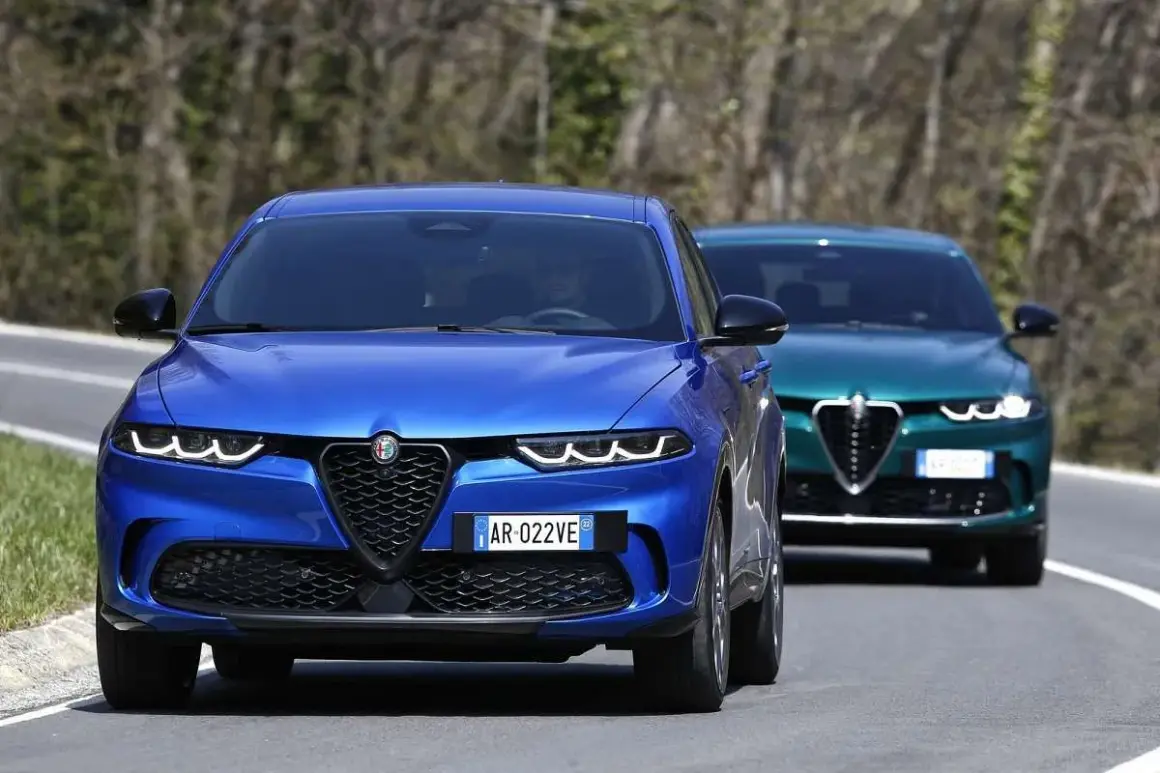 Dwa Alfa Romeo Tonale, jeden niebieski z przodu, drugi zielony z tyłu, jadą drogą. Sprawdź alfa romeo tonale cena.