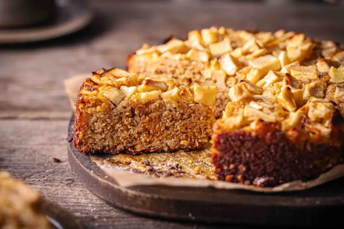 Ein saftiger Haferflocken Kuchen mit Apfelstücken, auf einem Holzbrett, bereit zum Genießen.