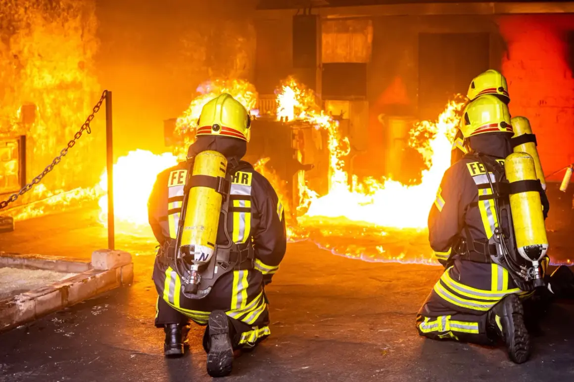 Zwei Feuerwehrleute in voller Montur knien vor einem intensiven Feuer. Ihre Ausbildung bei der Berufsfeuerwehr bereitet sie auf solche Einsätze vor.