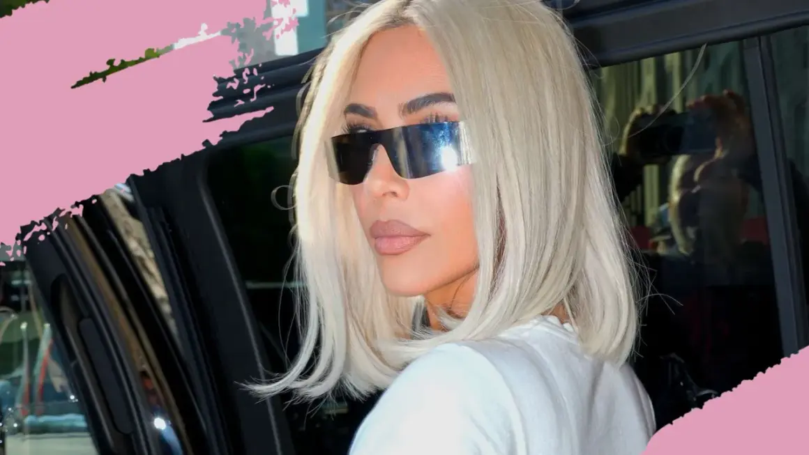 Frau mit platinblonden Haaren und futuristischen Sonnenbrillen steigt aus einem Auto.