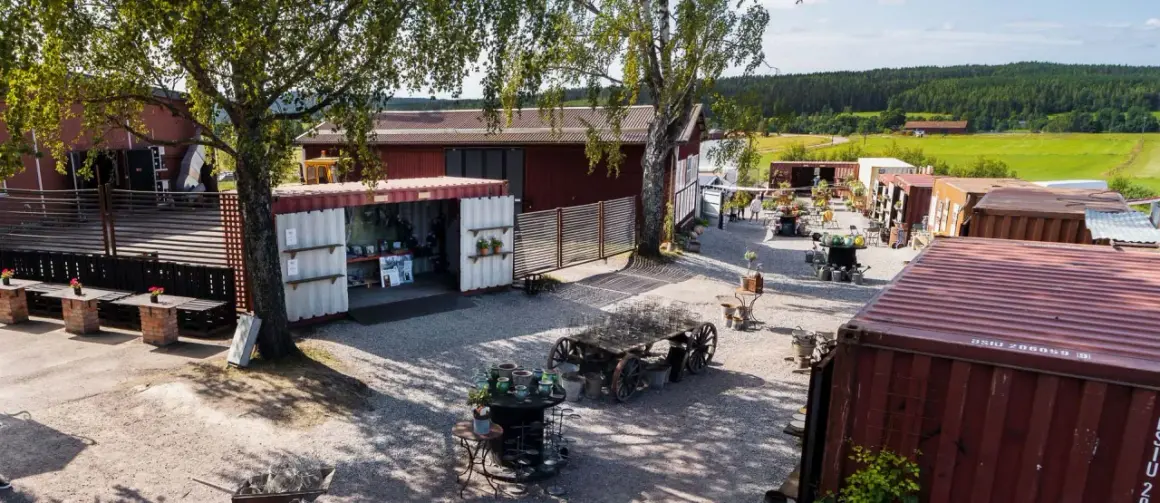 En charmig gårdsbutik i Stora Skedvi med varor utställda i containrar och på gamla vagnar.