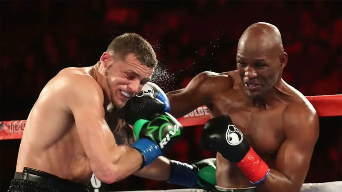 Bernard Hopkins lands a punch, sending a spray of sweat from his opponent's face during a fierce boxing match.