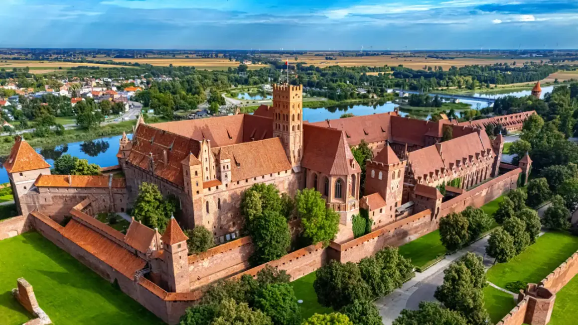 Zamek w Malborku, jedna z największych atrakcji Żuław Wiślanych, majestatycznie wznosi się nad rzeką Nogat.