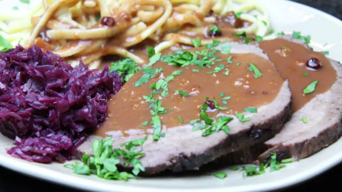Sauerbraten rezept: Zarte Scheiben Braten mit dunkler Soße, dazu Rotkohl und Spätzle. Ein Klassiker der deutschen Küche.