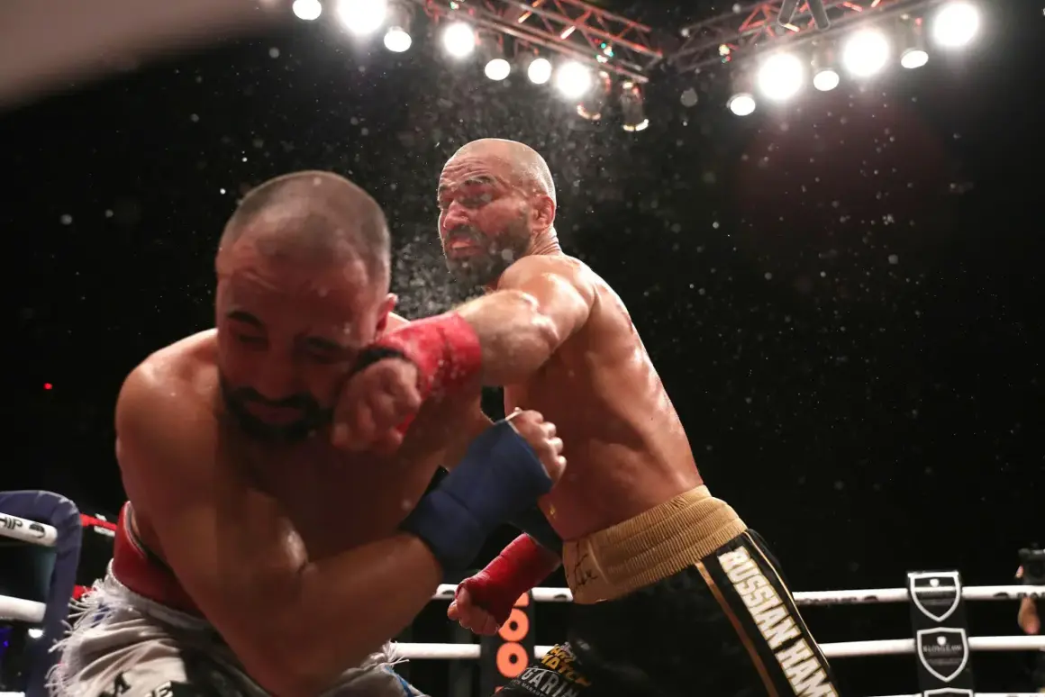 En slagväxling i MMA-ringen. En fighter med röd lindning på handen levererar en kraftfull träff mot motståndarens ansikte. Kanske är detta den bästa MMA-fightern i aktion.