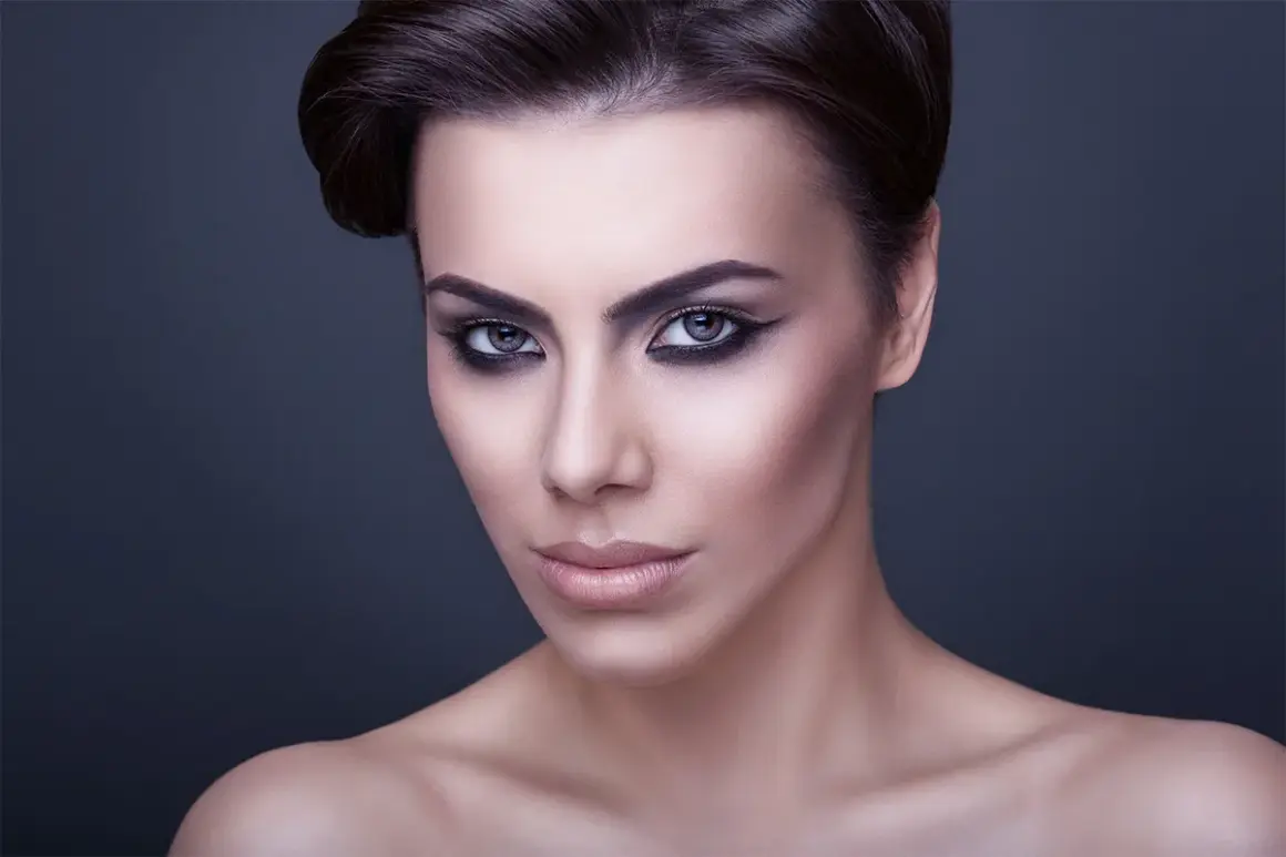 Volto di donna con trucco drammatico, labbra carnose e occhi all'ingiù che catturano lo sguardo.