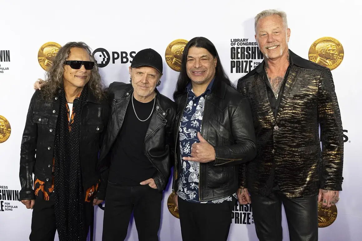 Członkowie zespołu Metallica pozują do zdjęcia. Kirk Hammett, Lars Ulrich, Robert Trujillo i James Hetfield wyglądają elegancko.