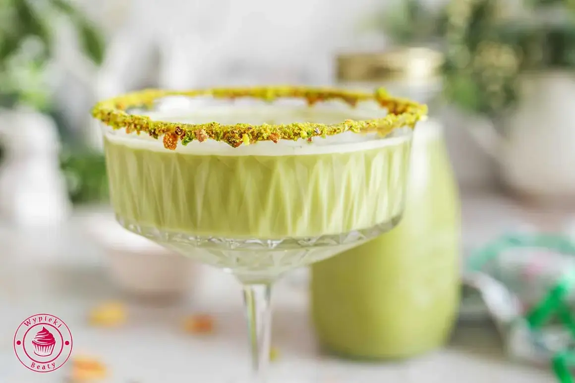 Zielony likier pistacjowy w kieliszku z posypką z pistacji. Idealny na specjalne okazje, oto prosty likier pistacjowy przepis.