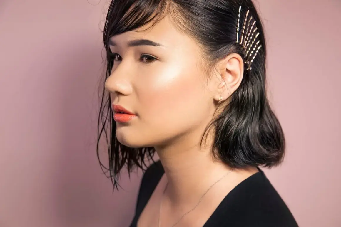 Ein Mädchen mit dunklen, nassen Haaren, die mit Glitzer-Haarnadeln geschmückt sind. So kann man seine **Haare richtig stylen** für einen besonderen Look.