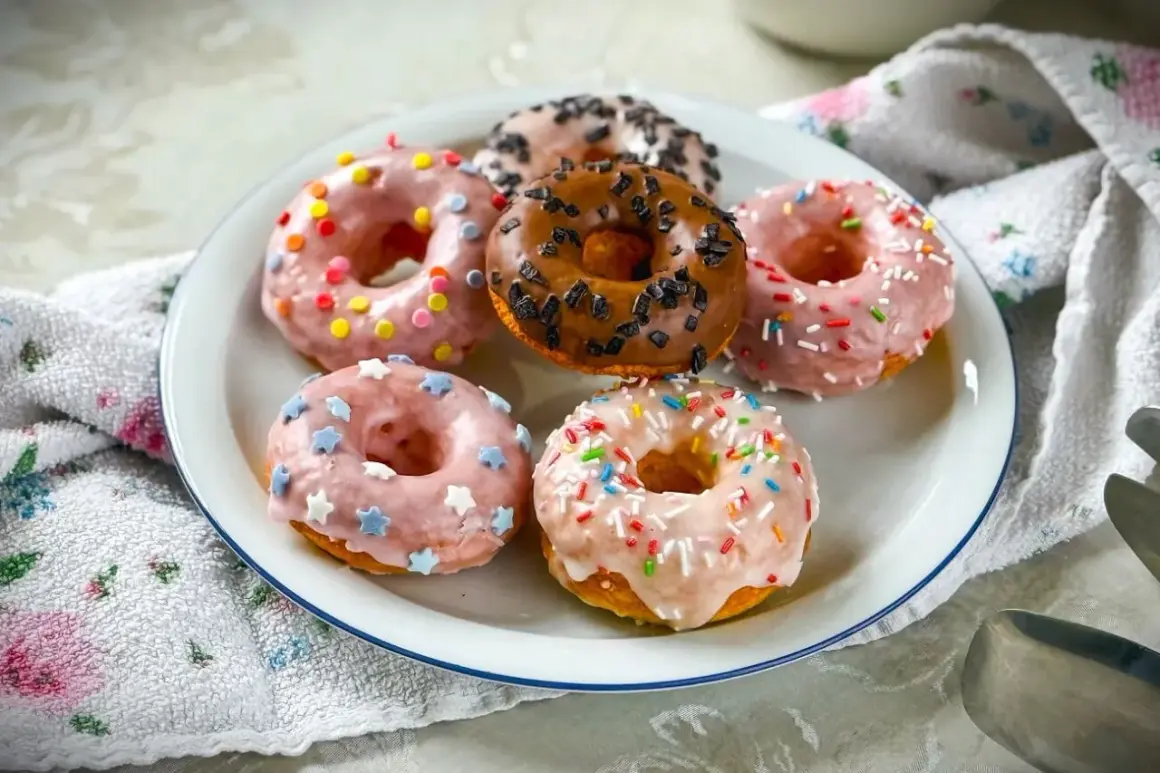Sechs bunte Donuts, die Lust aufs **Donuts selber machen** machen: Rosa mit Sternen, pink mit bunten Streuseln, braun mit Schokostreuseln und weitere.