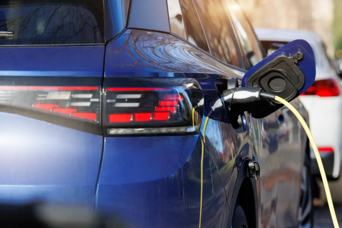 Niebieski samochód hybrydowy jest ładowany. To przyszłość motoryzacji, która łączy silnik spalinowy z elektrycznym.