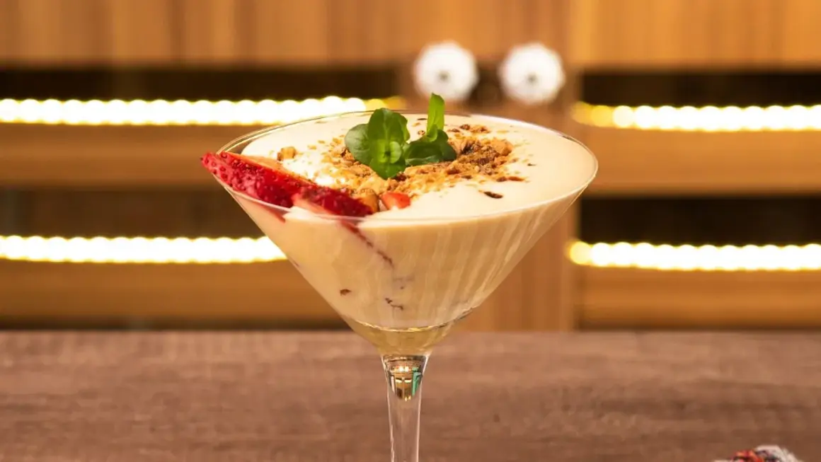 Delicioso sabayon de huevo en copa de martini, decorado con fresas y menta.