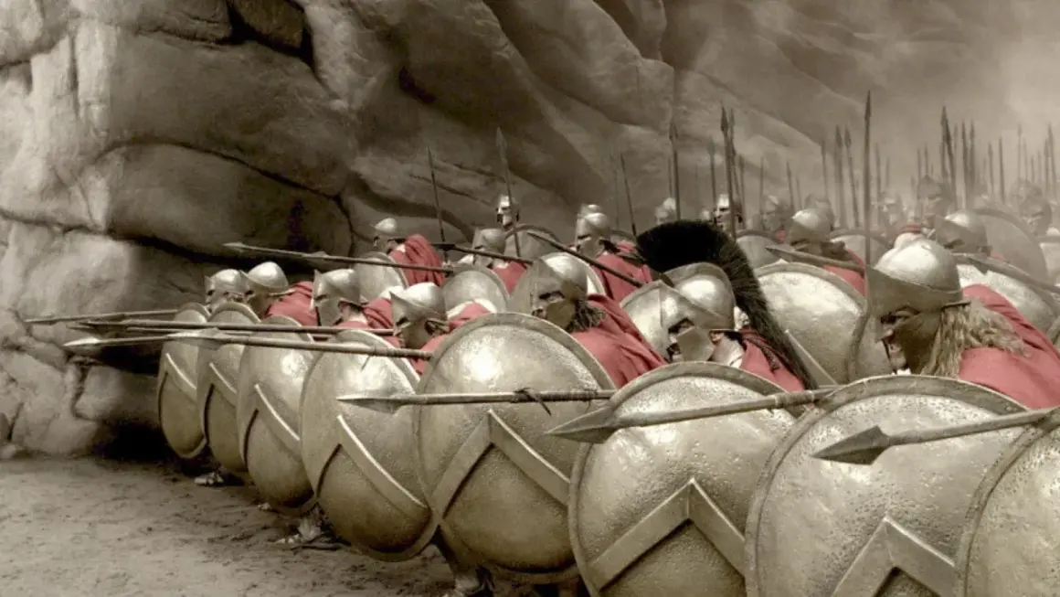Soldados espartanos en formación, listos para la batalla de Pidna. Escudos y lanzas apuntan al frente.