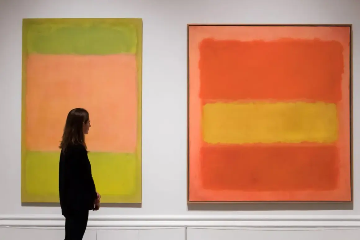 Kobieta podziwia abstrakcyjne dzieła sztuki obrazy Rothko: zielono-pomarańczowy i pomarańczowo-żółty.