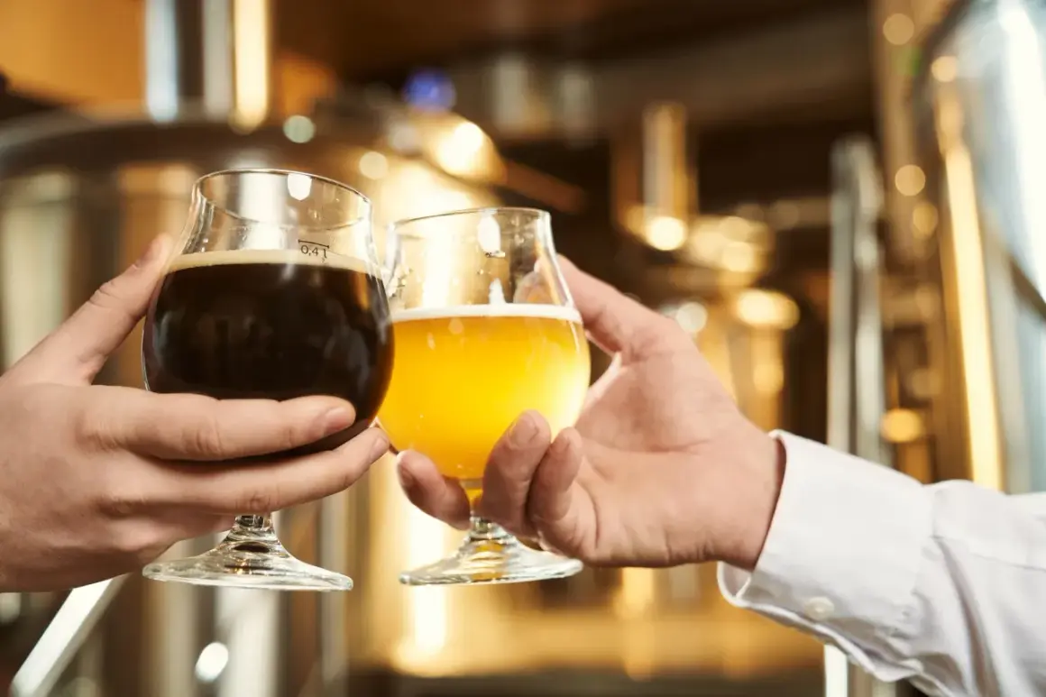 Dwie osoby wznoszą toast piwem. Zastanawiasz się, które piwo alkoholowe ma najmniej kalorii?