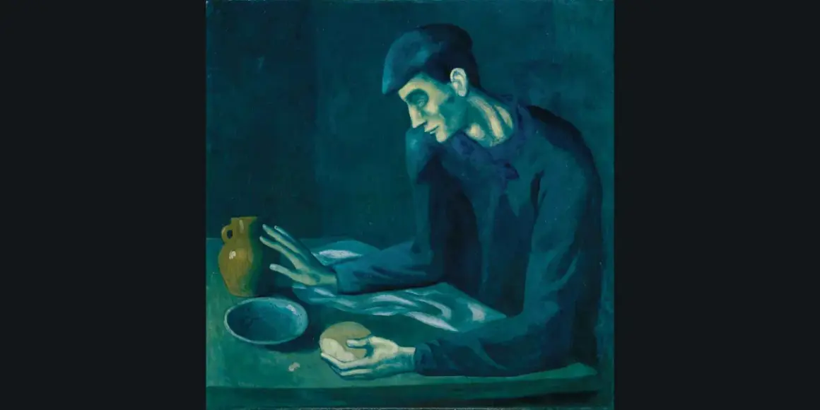 A man in a cap, characteristic of Picasso's Blue Period, sits at a table with a jug and bread, his face illuminated by a somber, blue light.