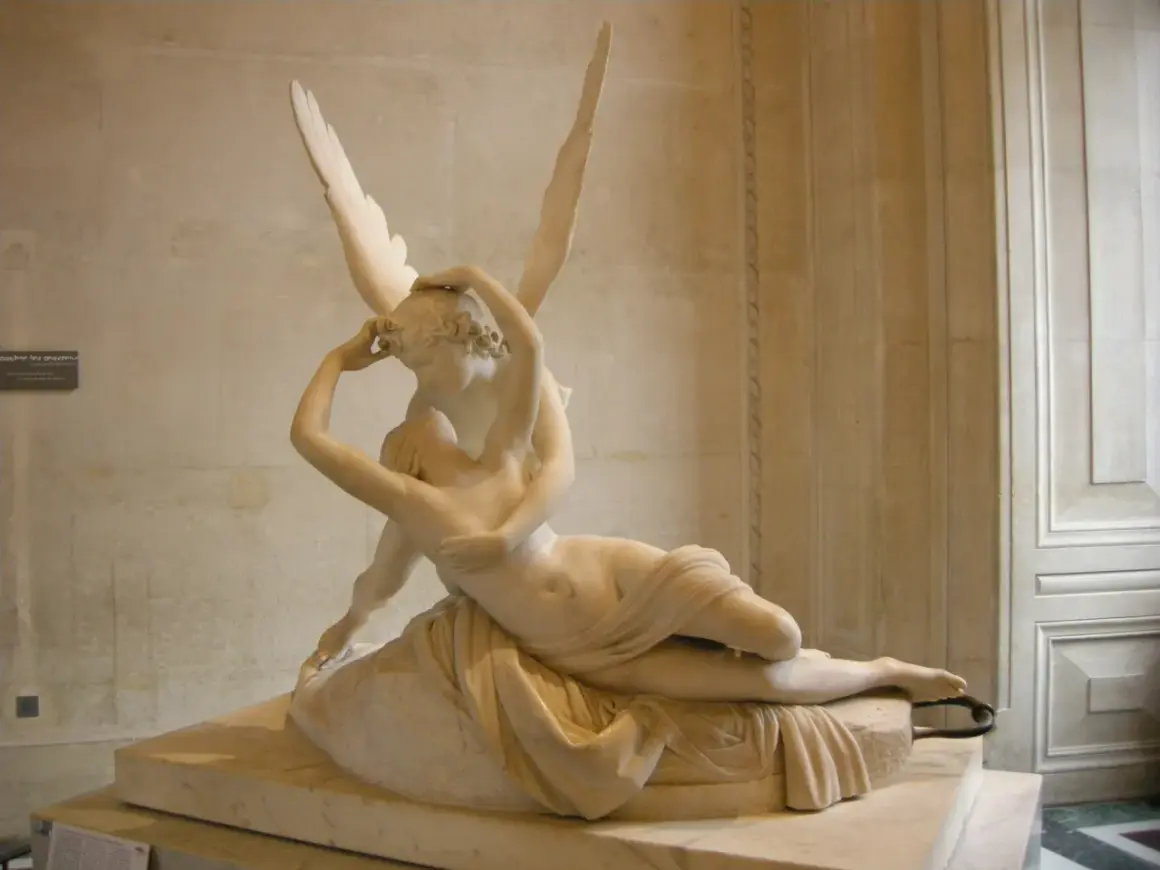 Een beeld van Eros, de god van de liefde, die Psyche kust. De vleugels van Eros zijn wijd gespreid.