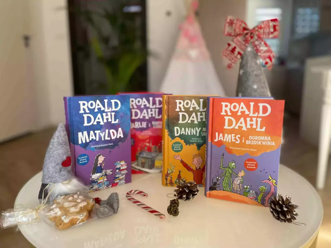 Książki Roald Dahl: Matylda, Charlie i fabryka czekolady, Danny, James i olbrzymia brzoskwinia. W tle świąteczne dekoracje.