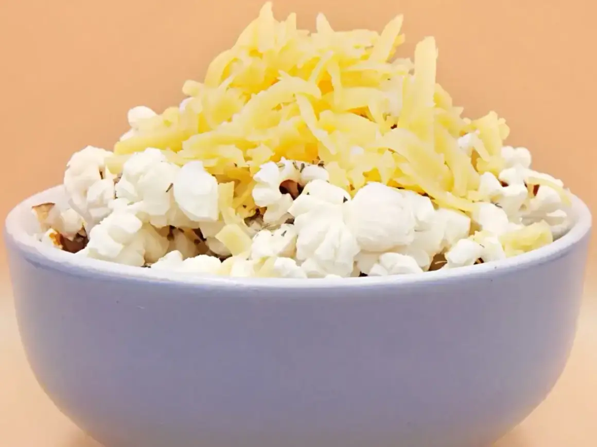Miseczka popcornu z tartym serem. Pyszna przekąska, ale warto pamiętać o jej popcorn kcal.