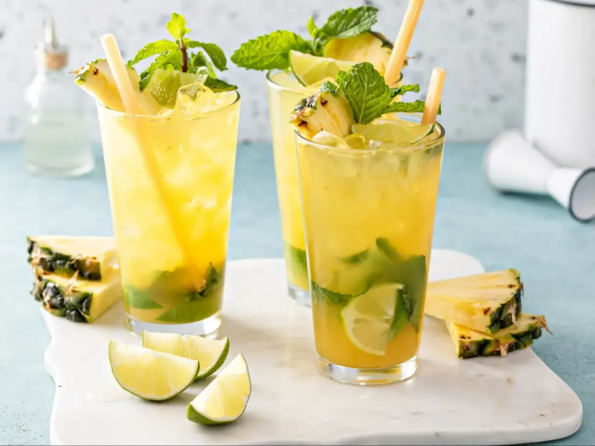 Orzeźwiające augustowskie mojito z ananasem, miętą i limonką, podane z kostkami lodu i słomkami.