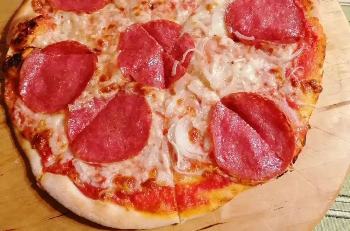 Pizza z salami i cebulą. Czy to pepperoni? Różnica między salami a pepperoni jest subtelna, ale ta pizza z pewnością smakuje wyśmienicie!