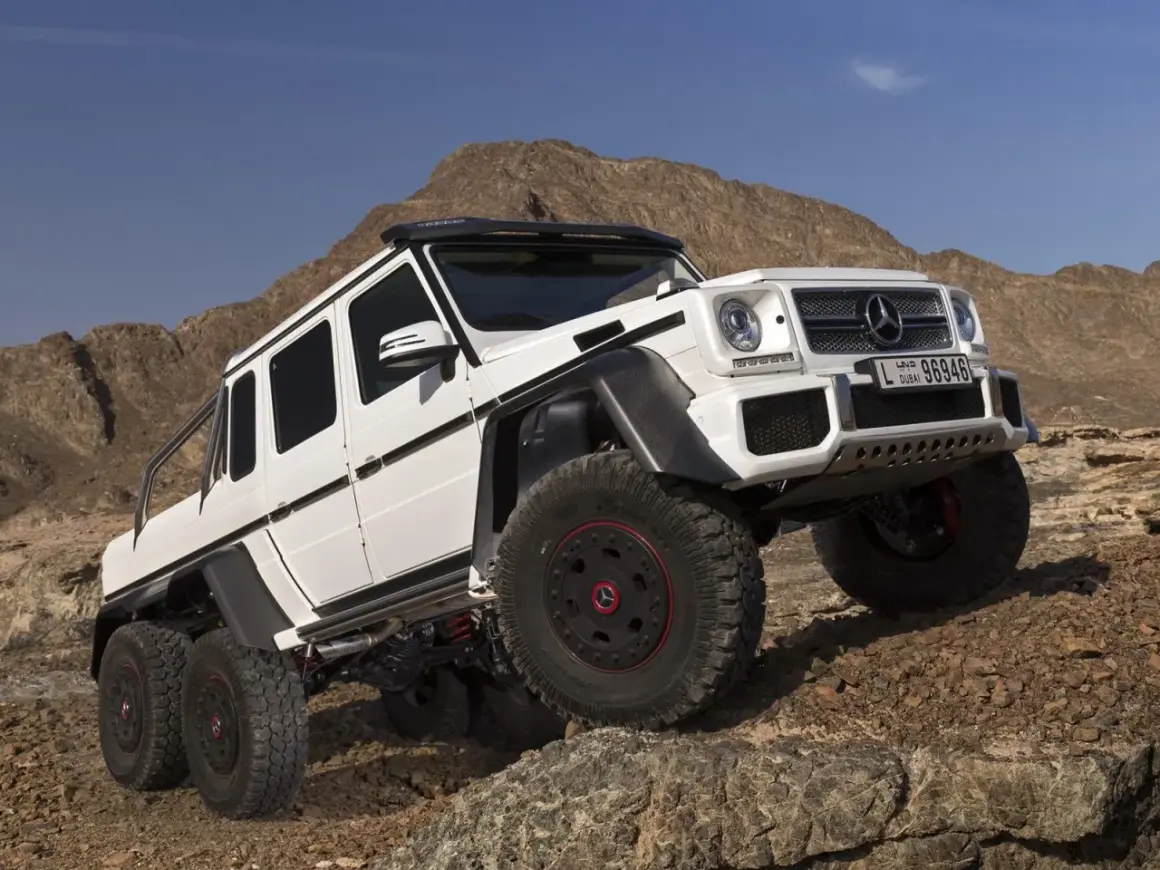 Biały Mercedes G63 AMG 6x6 z sześcioma kołami na skalistym pustynnym terenie.