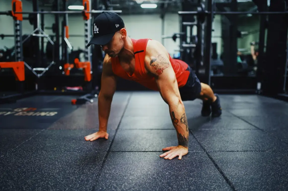 Mann in einem Fitnessstudio macht Liegestütze, um seinen Bewegungsradius zu verbessern.