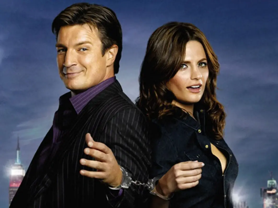 Die besetzung von Castle: Nathan Fillion und Stana Katic, mit Handschellen gefesselt, vor einer nächtlichen Skyline.